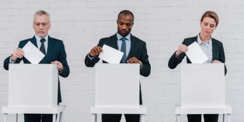 Three adults at voting booths