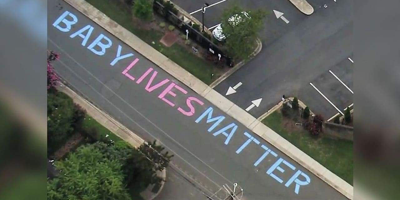 "Baby Lives Matter" written on a street|Protestors painting the words "Black Lives Matter" on the street in front of Trump Tower