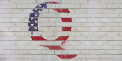 The letter Q painted on a white brick wall