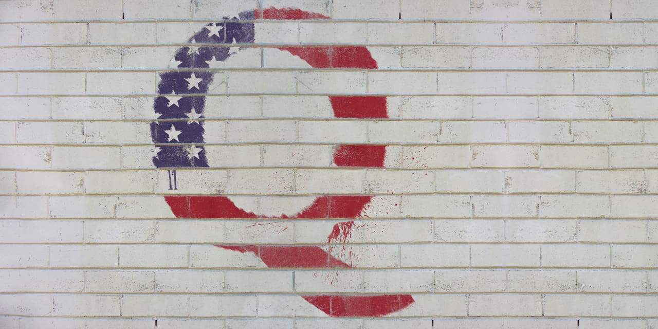 The letter Q painted on a white brick wall