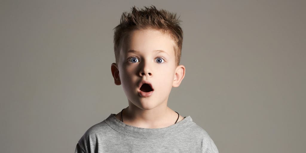 A boy who looks like he is shocked about something he sees
