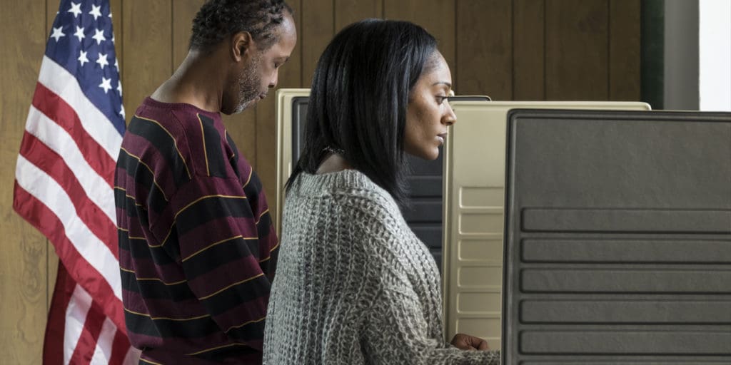 An African-American man and woman at a voting booth