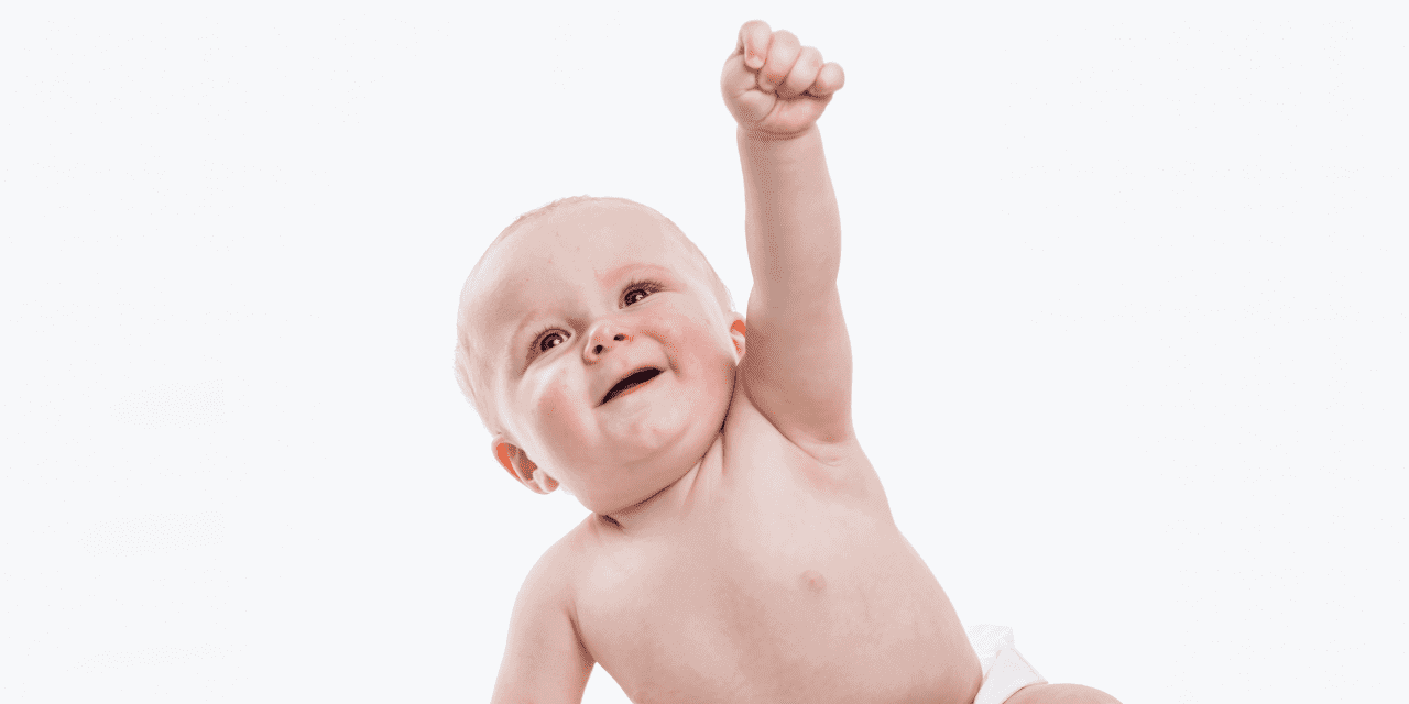 Baby lifting a fist toward the sky in excitement