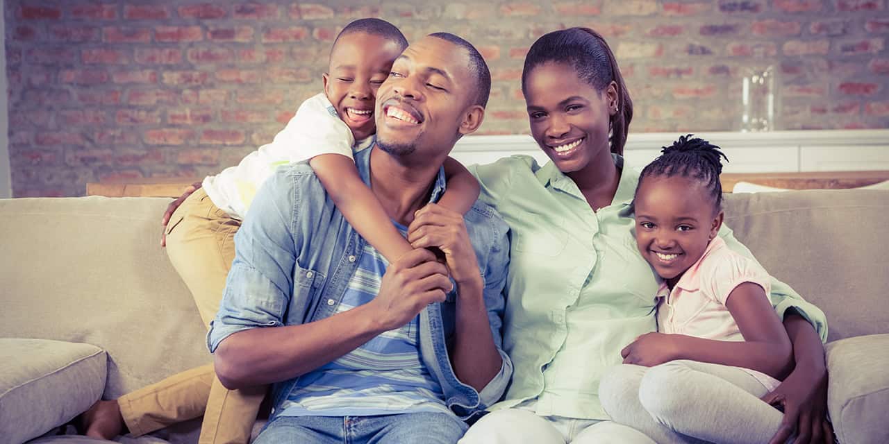 Black family sitting on the couch together