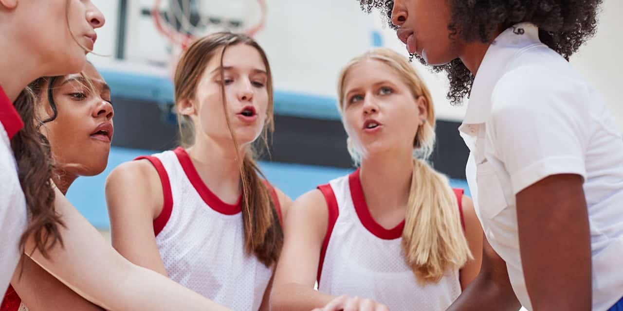 Girls doing a chant before their sports game