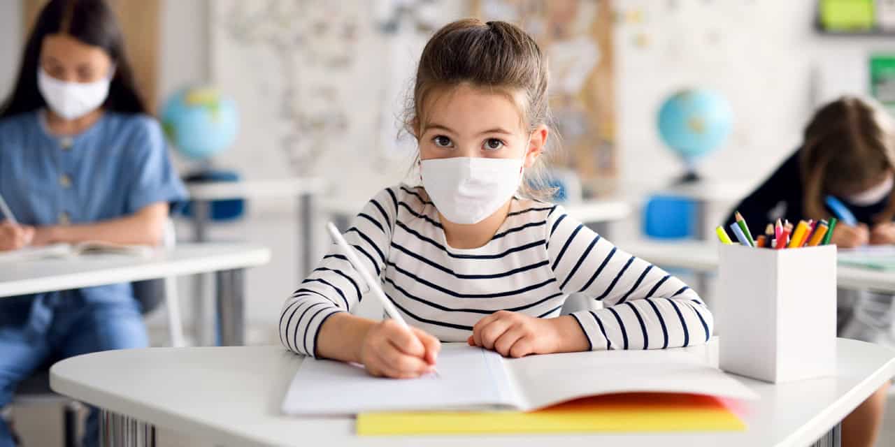 Girl wearing mask in classroom|