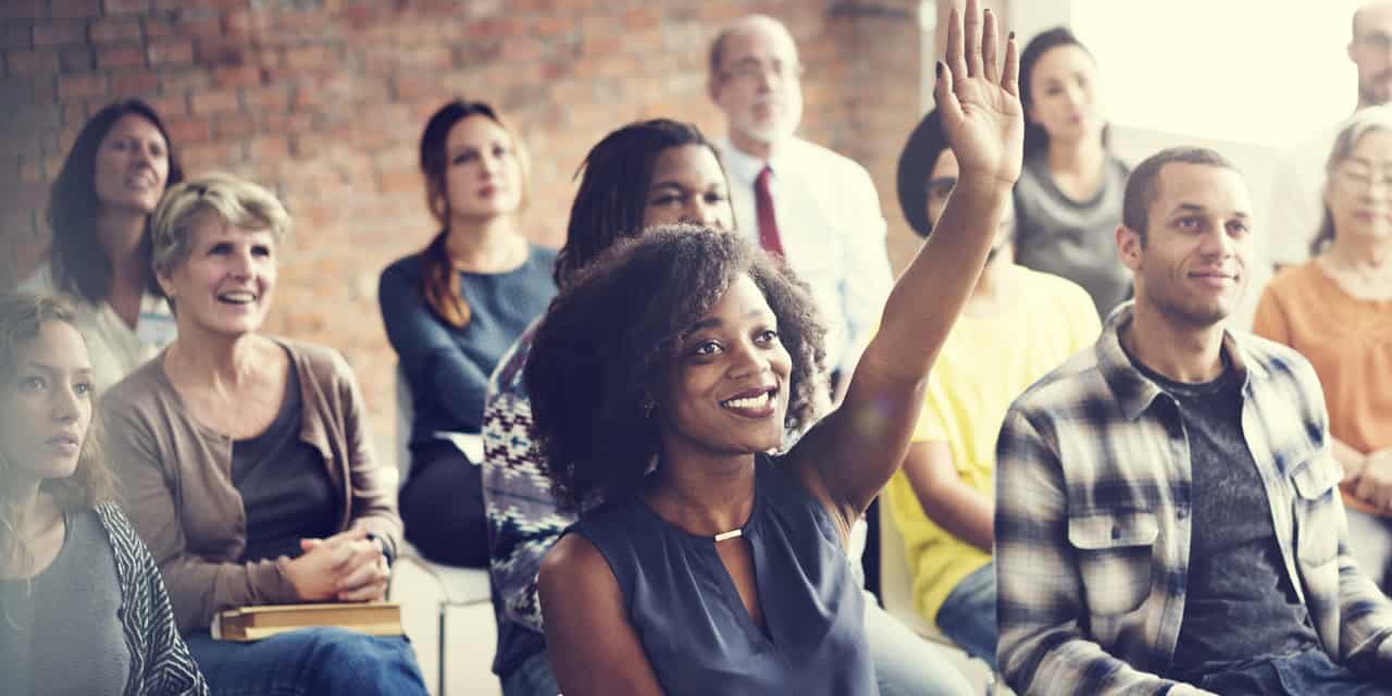 Woman raising her hand in a conference setting