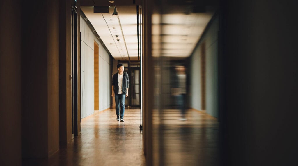 Boy walking down school hallway