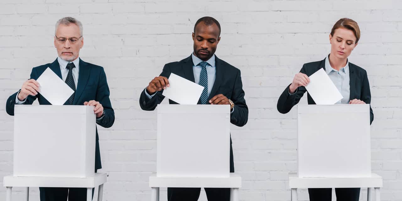 Three adults at voting booths